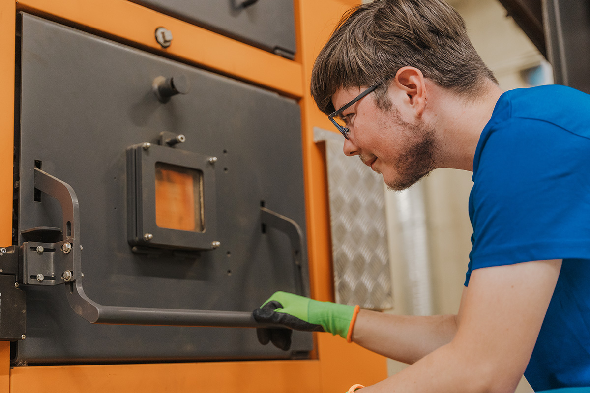 Du arbeitest mit ganz verschiedenen Heizsystemen. Hier im Bild ist eine Hackschnitzelanlage.