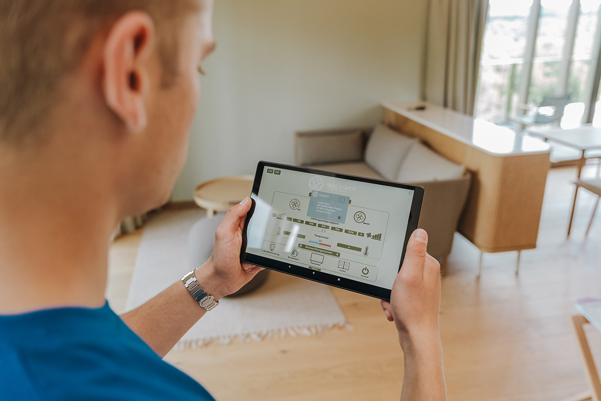 Ein Beispiel aus dem Hotel WALD.WEIT, das von uns gebaut wurde: Gäste können im Zimmer Temperatur, Licht und mehr über das Tablet regeln. Du sorgst dafür, dass das klappt.