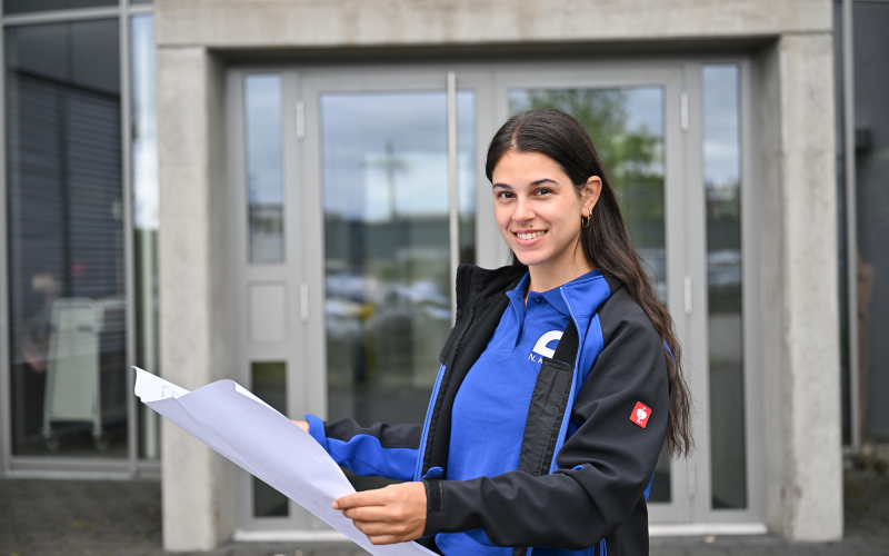 Nefeli mit Bauplan vor dem Gemünden-Verwaltungsgebäude